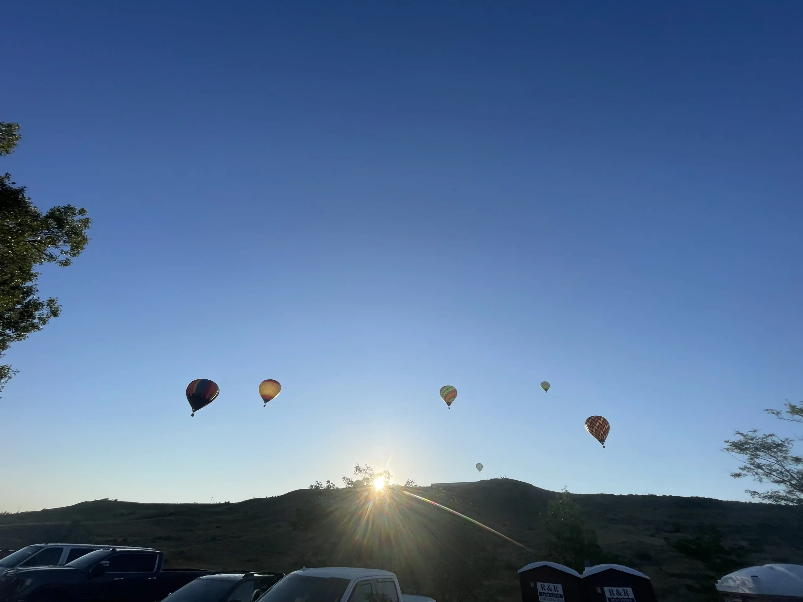 Photo of hot air balloons floating against a clear blue sky in Casper WY
